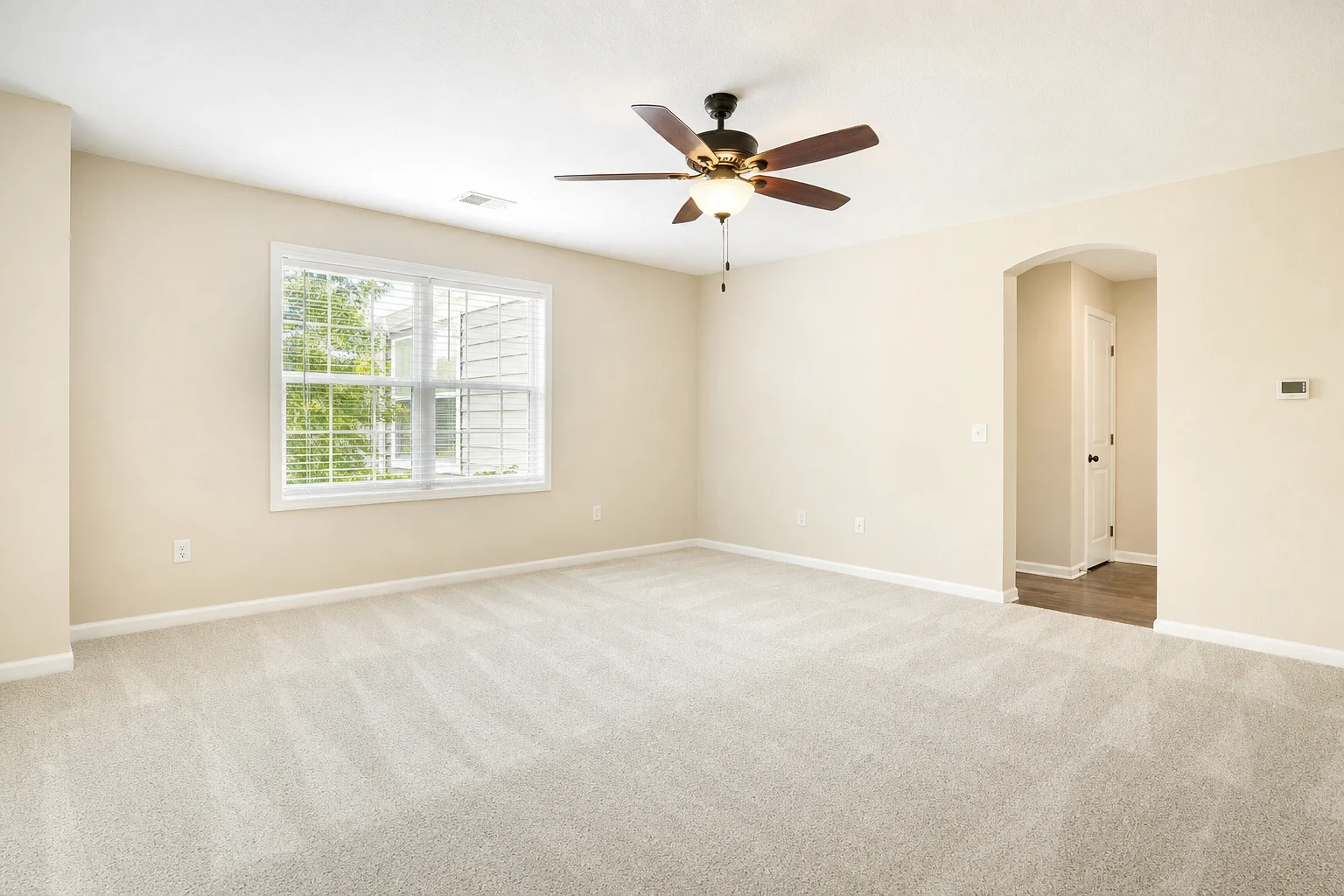 An empty, freshly deep-cleaned living room — vacuum lines, dust-free baseboards, move-out ready